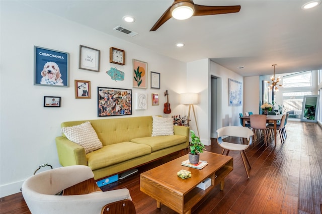 living room featuring dark hardwood / wood-style flooring and ceiling fan with notable chandelier