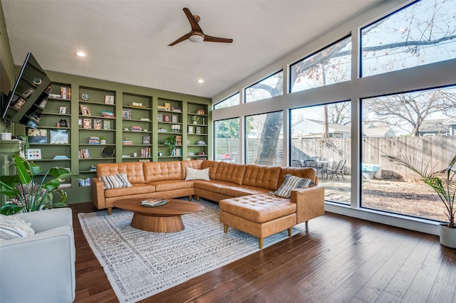 living room featuring dark wood-type flooring, ceiling fan, and built in features