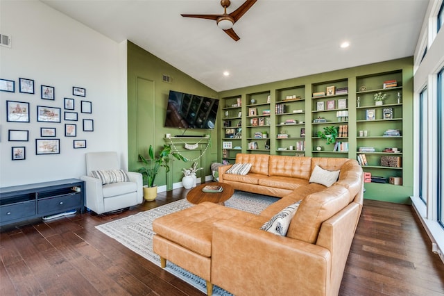 living room with dark wood-type flooring, vaulted ceiling, built in shelves, and ceiling fan