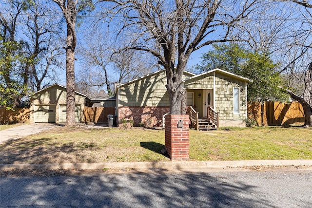 view of front facade featuring concrete driveway, an attached garage, fence, a front yard, and brick siding