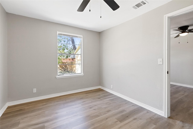 empty room featuring baseboards, visible vents, ceiling fan, and light wood finished floors