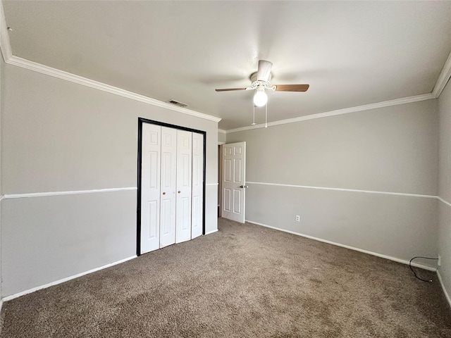 unfurnished bedroom featuring crown molding, a closet, ceiling fan, and carpet flooring