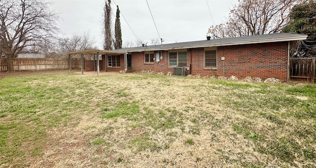 rear view of house featuring a patio, a yard, and central AC