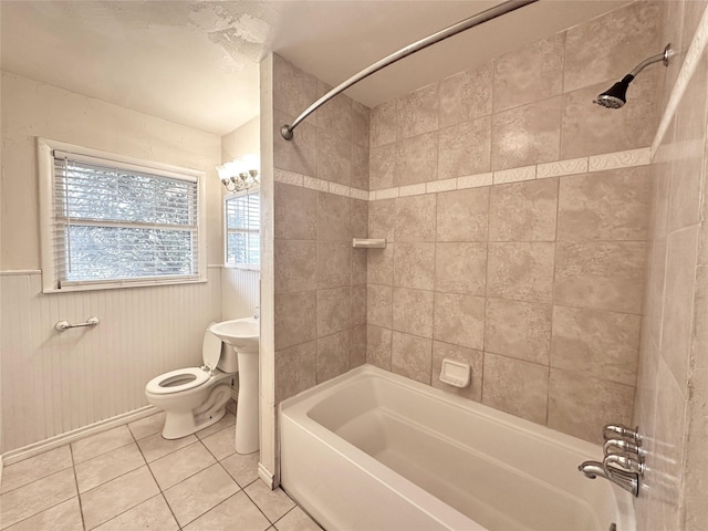 bathroom featuring tiled shower / bath, tile patterned floors, and toilet