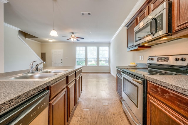 kitchen featuring appliances with stainless steel finishes, decorative light fixtures, sink, crown molding, and light hardwood / wood-style flooring