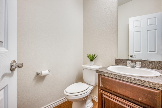 bathroom featuring hardwood / wood-style flooring, vanity, and toilet