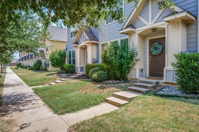 entrance to property featuring a lawn