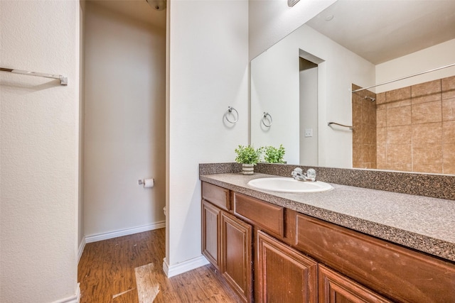 bathroom with vanity, wood-type flooring, and a tile shower