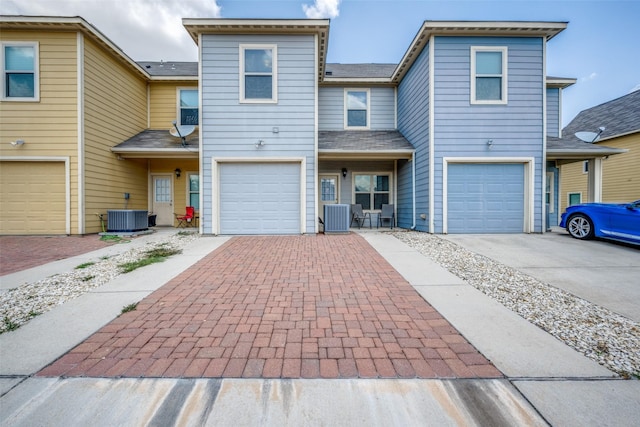 view of front of house featuring a garage and central AC