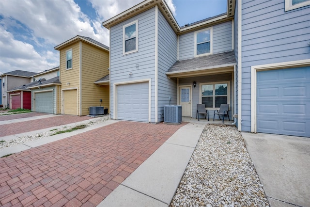 multi unit property featuring a garage and central air condition unit