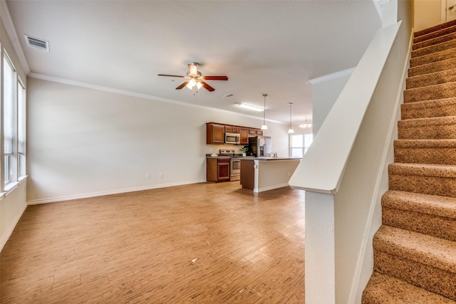 unfurnished living room featuring crown molding, ceiling fan, and light wood-type flooring