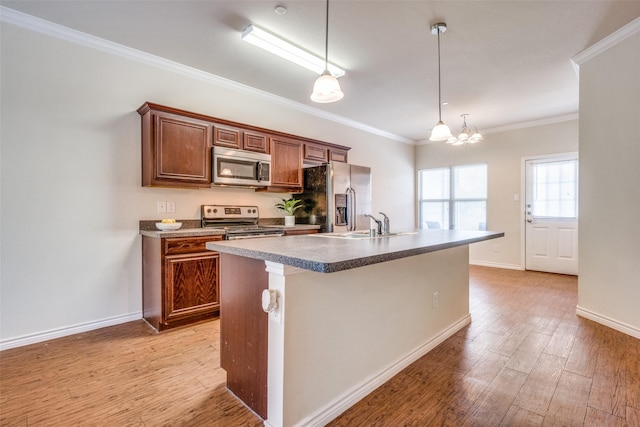 kitchen featuring appliances with stainless steel finishes, a kitchen island with sink, hanging light fixtures, and light wood-type flooring