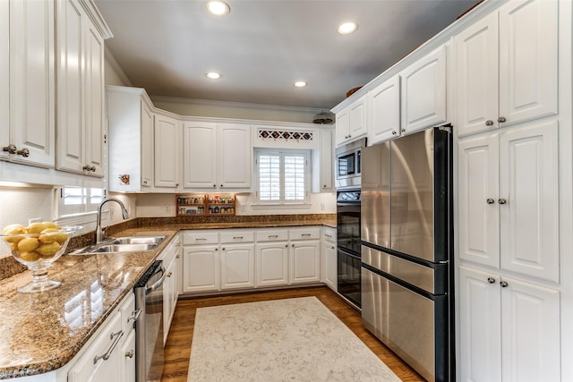 kitchen featuring ornamental molding, appliances with stainless steel finishes, sink, and white cabinets