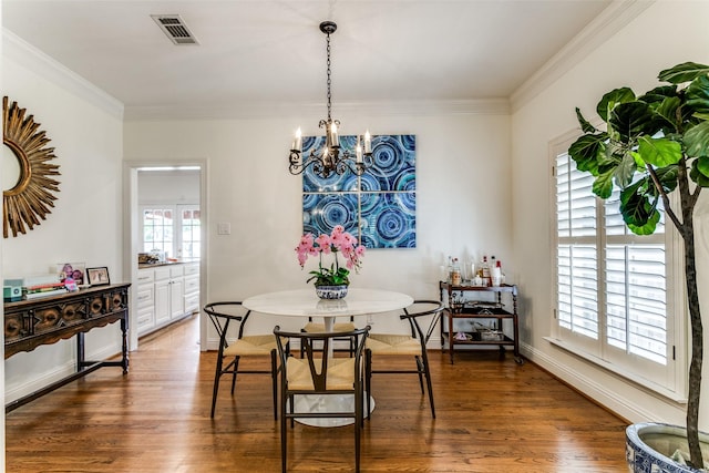 dining room featuring dark hardwood / wood-style flooring, a notable chandelier, crown molding, and a healthy amount of sunlight