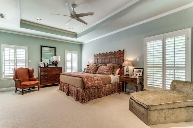 bedroom with ornamental molding, a raised ceiling, light carpet, and multiple windows