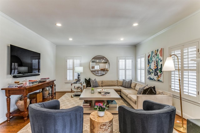 living room featuring wood-type flooring, a healthy amount of sunlight, and crown molding