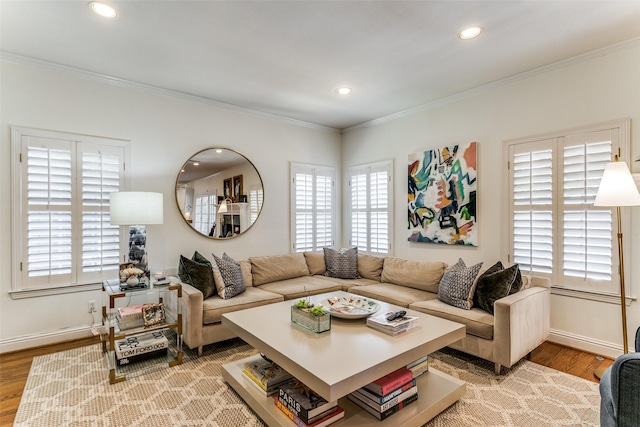 living room featuring light hardwood / wood-style flooring, ornamental molding, and a healthy amount of sunlight