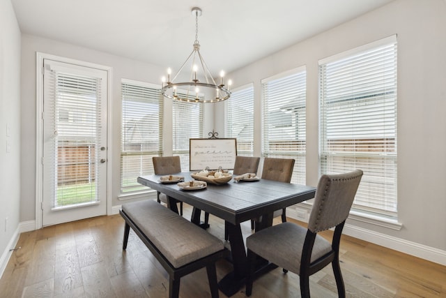 dining room featuring baseboards, plenty of natural light, and light wood-style floors