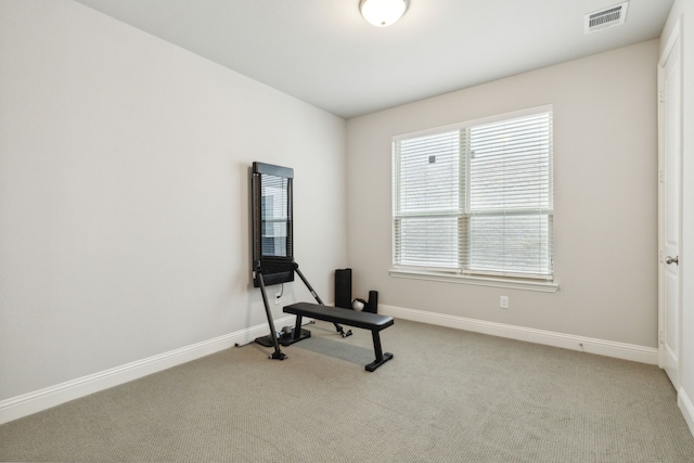 exercise area with visible vents, baseboards, and carpet flooring