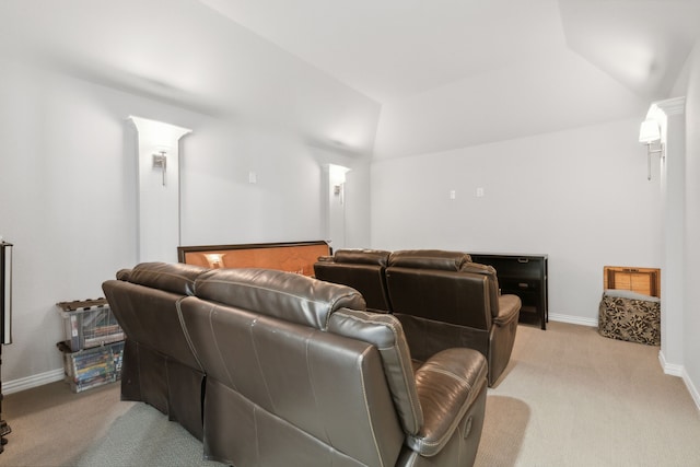 home theater featuring vaulted ceiling, baseboards, and light carpet