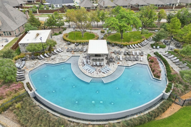 view of swimming pool with outdoor dry bar, a residential view, a patio, and fence