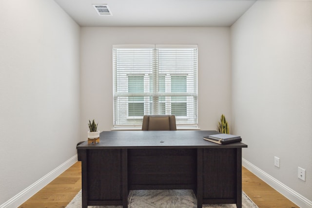 office with visible vents, baseboards, and light wood-style flooring