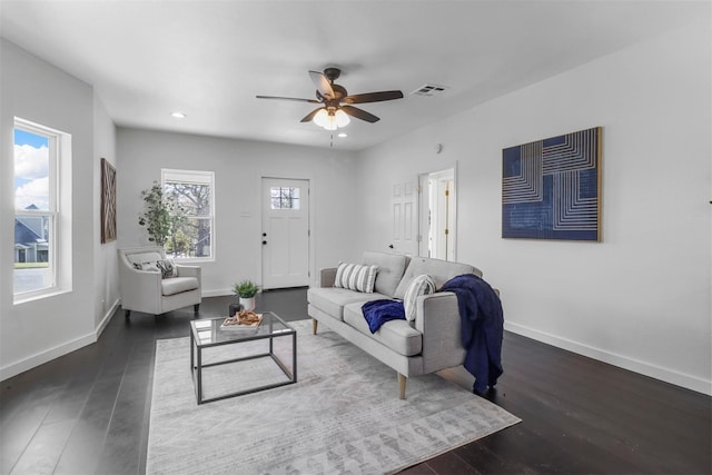 living room featuring dark wood-type flooring and ceiling fan