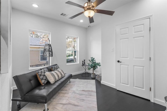 living area with hardwood / wood-style flooring and ceiling fan