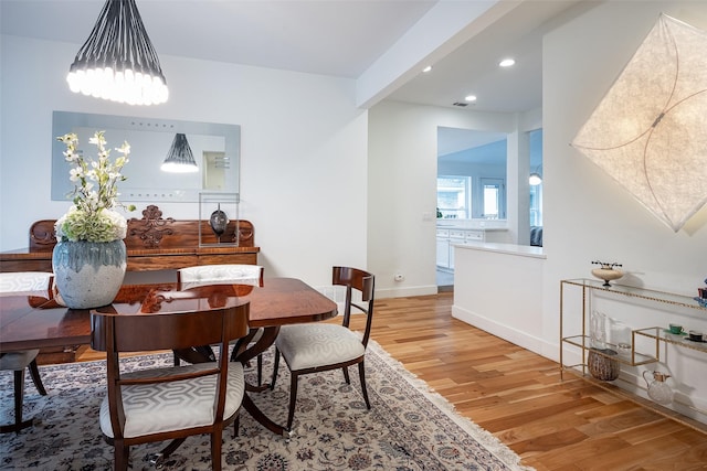 dining room with hardwood / wood-style flooring and beamed ceiling