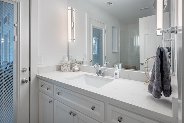 bathroom featuring vanity and a shower with door