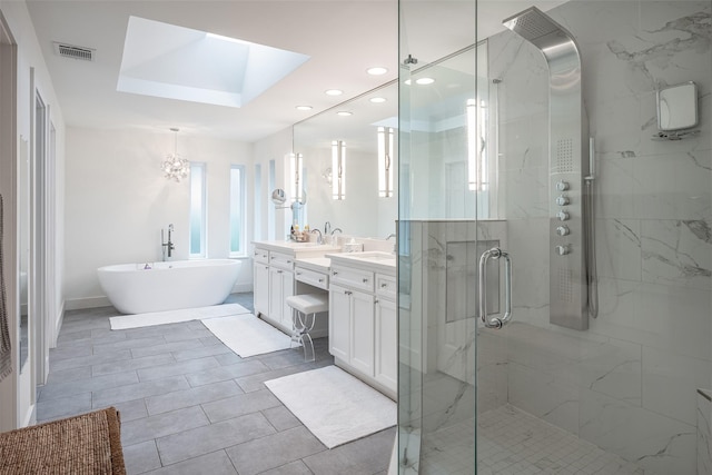 bathroom with a skylight, vanity, and independent shower and bath