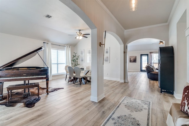 interior space featuring crown molding, vaulted ceiling, ceiling fan, and light hardwood / wood-style flooring