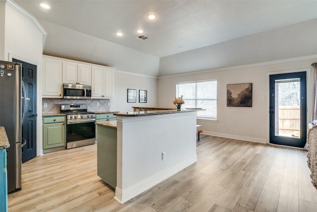 kitchen with backsplash, light hardwood / wood-style floors, white cabinets, and appliances with stainless steel finishes