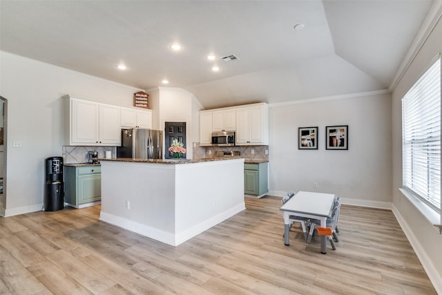 kitchen with stainless steel appliances, white cabinetry, vaulted ceiling, and a center island