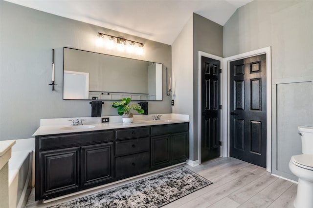 bathroom featuring vanity, hardwood / wood-style floors, and toilet