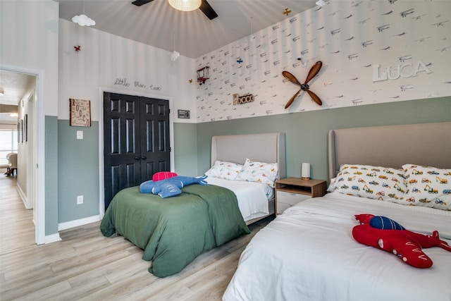 bedroom with ceiling fan, wood-type flooring, and a closet