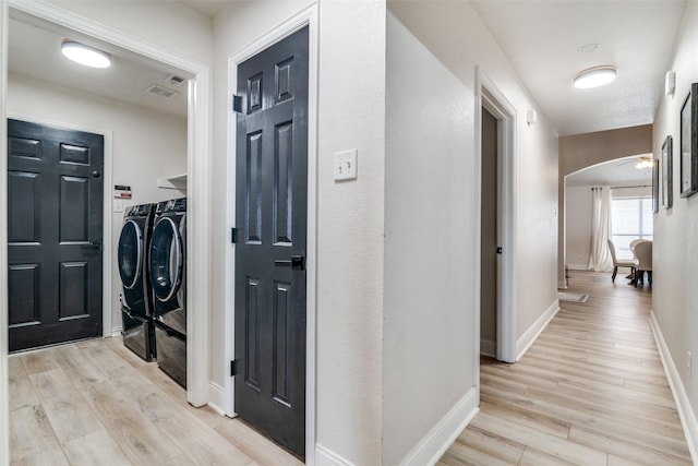 hallway with light hardwood / wood-style floors and washing machine and dryer