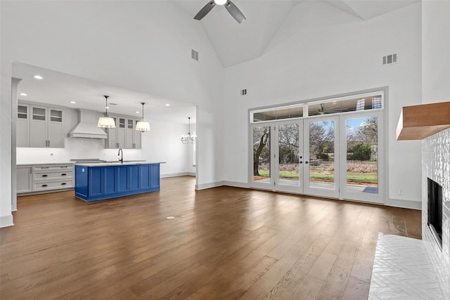 unfurnished living room featuring visible vents, dark wood finished floors, a sink, and a tiled fireplace