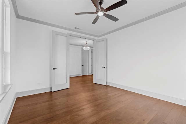 unfurnished room with ornamental molding, wood finished floors, visible vents, and a ceiling fan