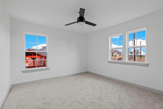 unfurnished room featuring light carpet, ceiling fan, and baseboards