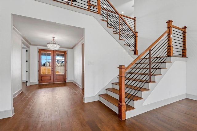 foyer featuring a chandelier, ornamental molding, dark wood finished floors, and baseboards