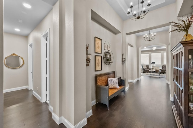 corridor with a notable chandelier and dark hardwood / wood-style floors