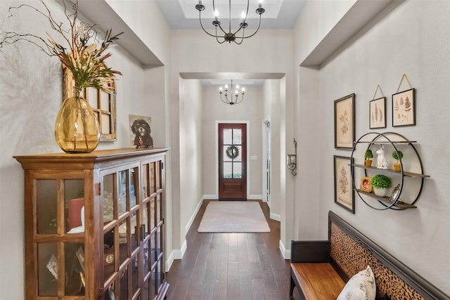 entryway featuring an inviting chandelier and dark hardwood / wood-style flooring