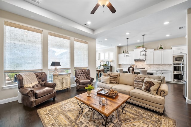 living room featuring ceiling fan, dark hardwood / wood-style flooring, and a wealth of natural light