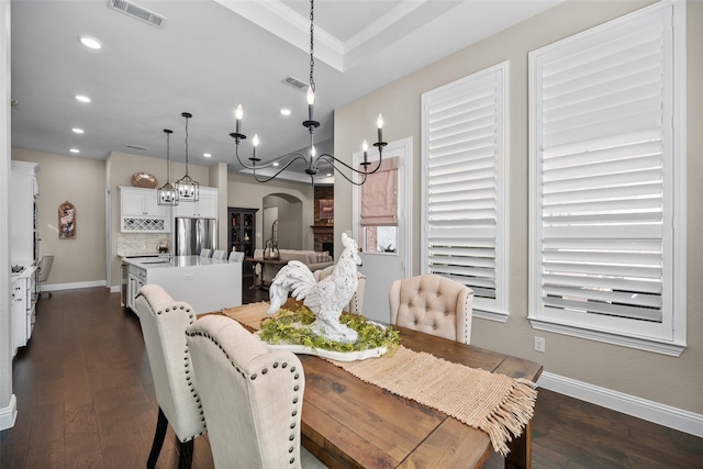 dining room with dark hardwood / wood-style flooring, sink, and an inviting chandelier