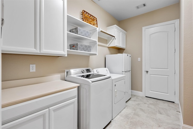 washroom with cabinets and washer and dryer