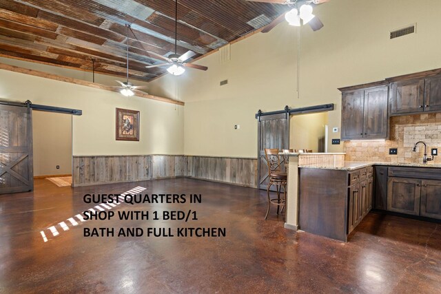 bathroom featuring vanity, toilet, and wood walls