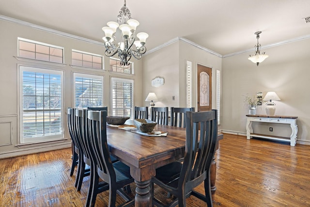 dining space featuring ornamental molding, dark wood-type flooring, and a chandelier