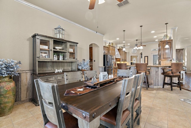 tiled dining space with crown molding and ceiling fan