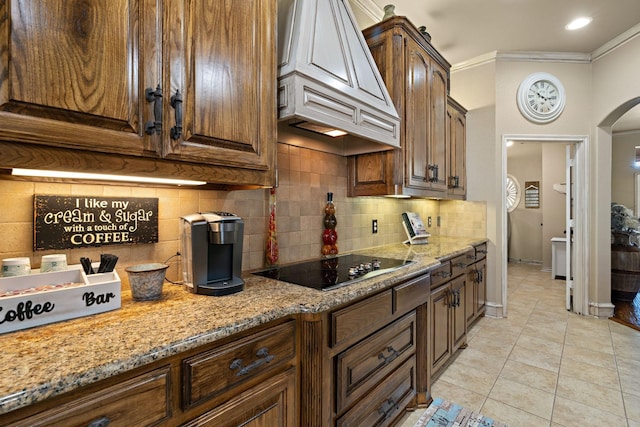 kitchen featuring custom exhaust hood, crown molding, light stone countertops, and light tile patterned floors